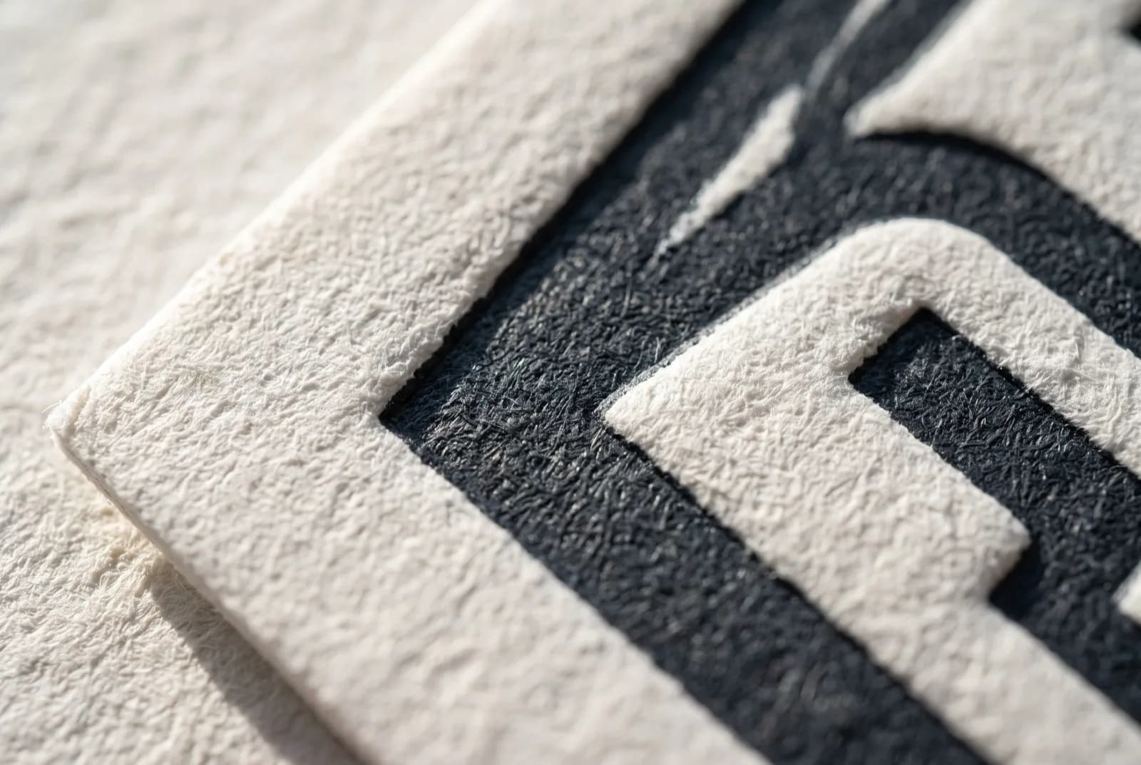 Macro close-up of a letterpress business card showing the deep inked impression pressed into thick cotton stock